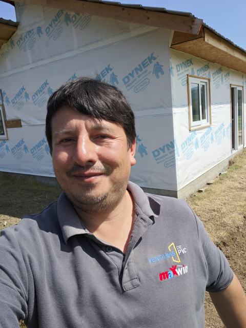 Instalador de Ventanas de PVC frente a casa con ventanas recién instaladas