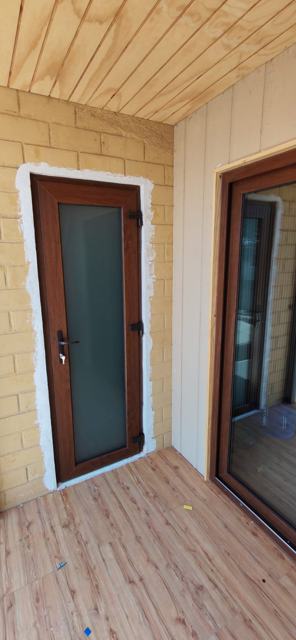 Puerta de PVC nogal con vidrio satinado en terraza
