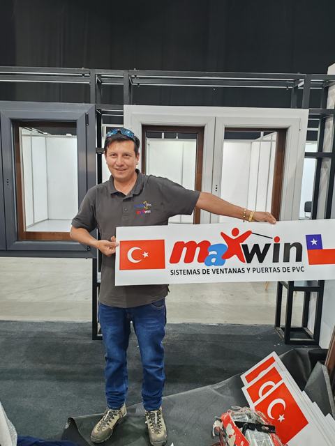 Ricardo Zuzunaga con el letrero de perfiles Maxwin en el stand de Ventanas de PVC