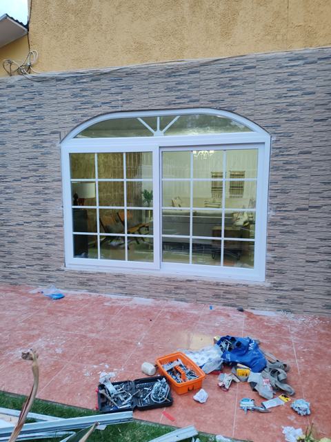 Ventana de PVC blanca con arco de medio punto y junquillos